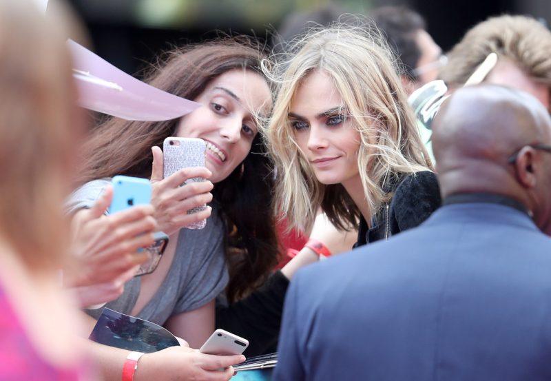 Cara Delevingne taking a selfie with a fan Cara Delevingne taking a selfie with a fan
