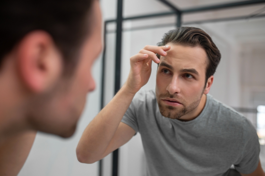 appearance young man grey tshirt looking his reflection mirror